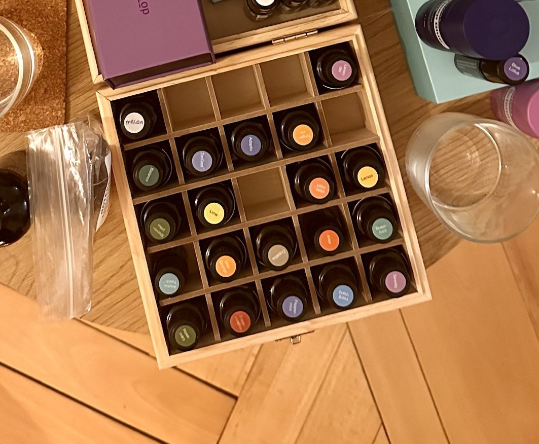 Table ronde préparée avec des coffrets d'huiles essentielles, des verres et des fruits secs