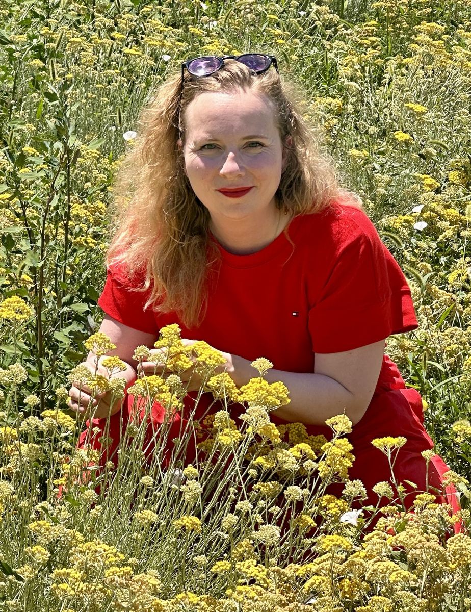 Pauline, praticienne en naturopathie, dans un champ de fleurs jaunes